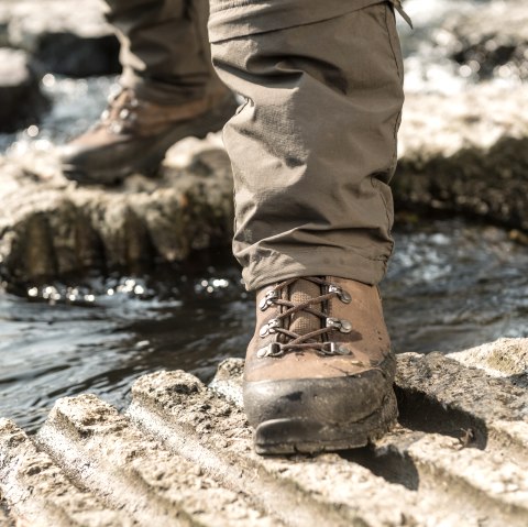 Ein Wanderstiefel steht auf einem Felsen über einem fließenden Bach. Der Stiefel ist braun und die Hose ist beige., © Eifel Tourismus GmbH, Dominik Ketz Ein Wanderstiefel steht auf einem Felsen über einem fließenden Bach. Der Stiefel ist braun und die Hose ist beige., © Eifel Tourismus GmbH, Dominik Ketz
