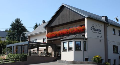 Ein charmantes Haus mit einem schönen Blumenfenster. Die Terrasse lädt zum Entspannen ein.