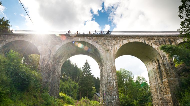 Radfahrer auf dem Reichensteiner Viadukt der Vennbahn bei Sonnenschein.
