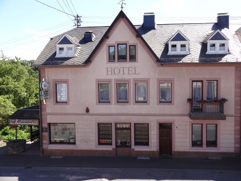 Ein gemütliches Hotelgebäude mit rosa Fassade und mehreren Fenstern. Über dem Eingang prangt das Wort "HOTEL".