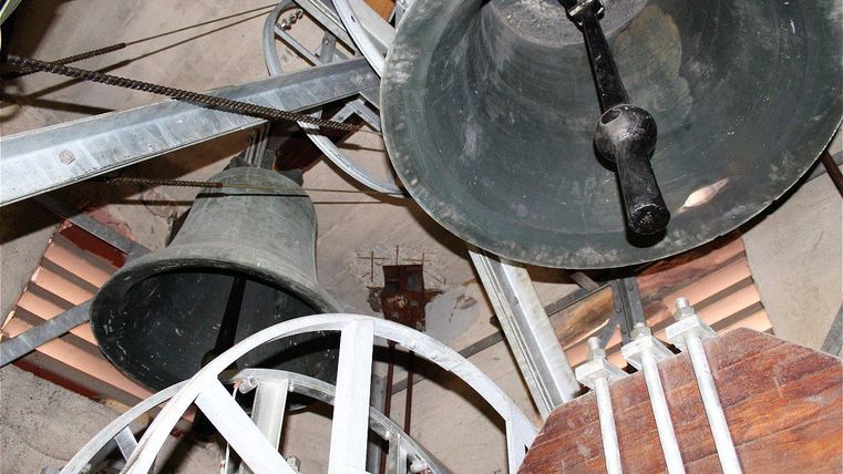 Eine Ansicht von Glocken in einem Turm. Die Struktur zeigt mechanische Teile und die Glocken sind sichtbar.