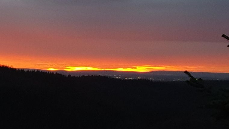 Ein wunderschöner Sonnenuntergang über den Bergen. Der Himmel leuchtet in warmen Farben und schafft eine ruhige Atmosphäre.
