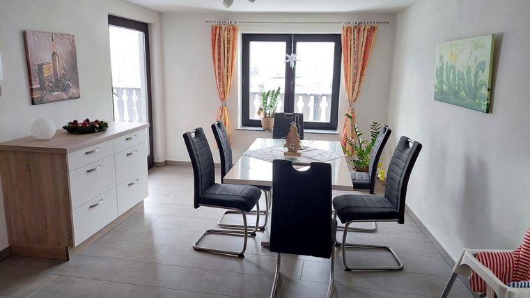 A modern dining area with a table and chairs. Large windows provide plenty of light and an inviting atmosphere.