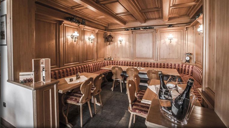 Ein gemütliches Restaurant mit warmen Holzverkleidungen und bequemen Sitzgelegenheiten. Die Beleuchtung sorgt für eine einladende Atmosphäre.